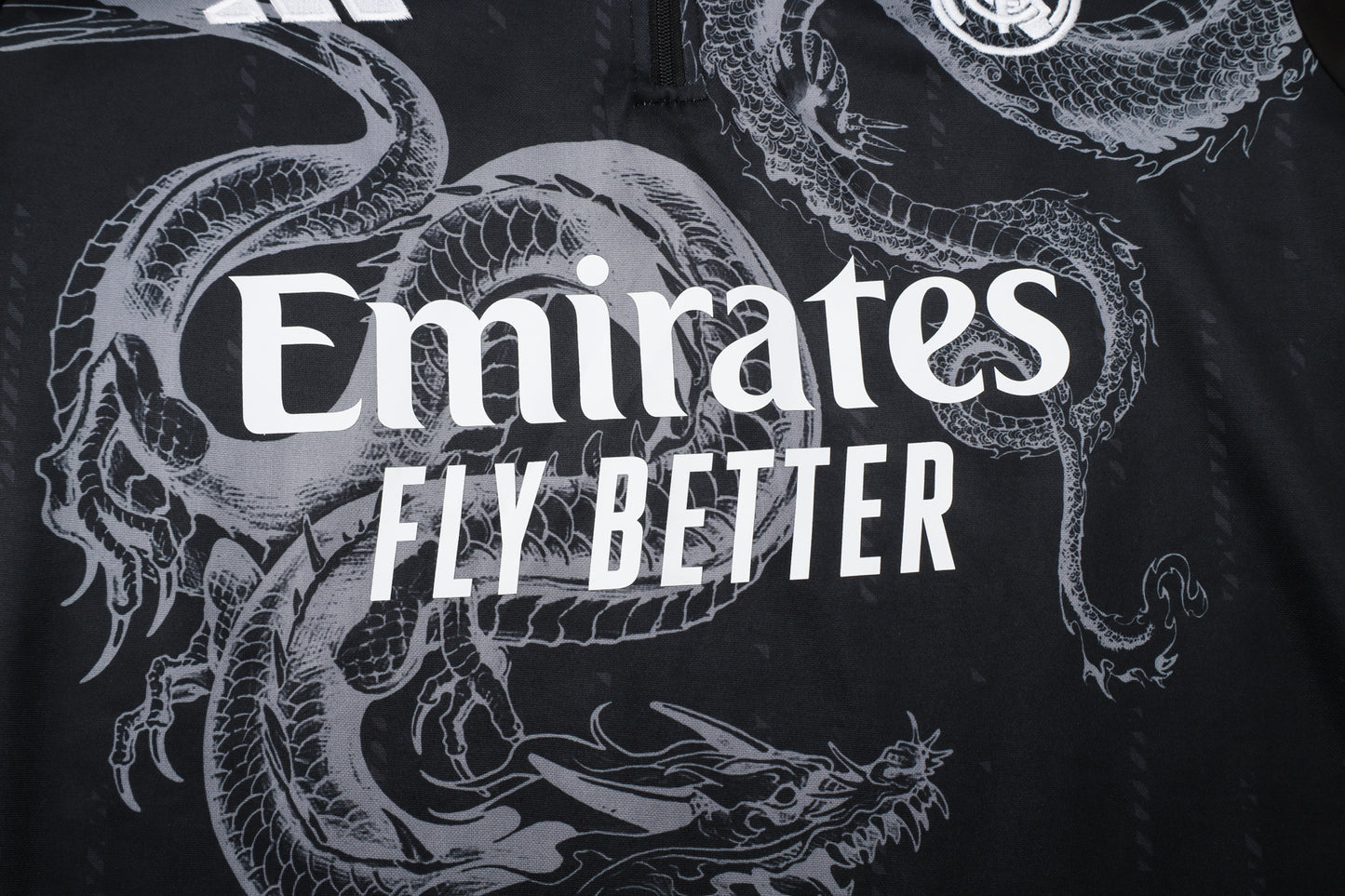 חליפת אימון ריאל מדריד 2024/25 – שחור ספריי עם חצי רוכסן ופסים לבנים